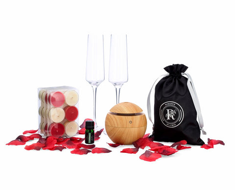 Image of tea light candles flutes rose petals essential oil diffuser and essential oil