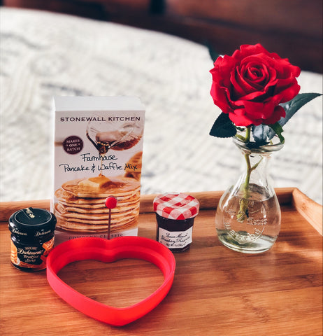 Image of pancake mix syrup strawberry jam heart-shaped mold and vase with a red rose on a breakfast tray table