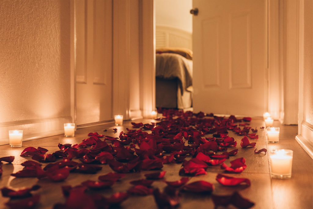 rose petals and candles on the floor leading to the bedroom